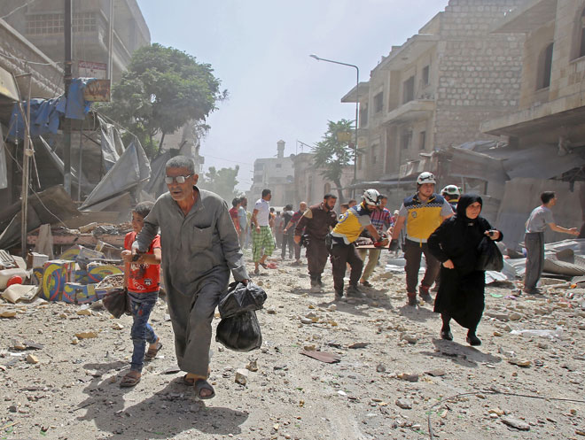  Anggota Pertahanan Awam Syria mengangkat lelaki yang cedera dengan pengusung ketika penduduk melarikan diri selepas pengeboman ke atas bandar Maaret al-Numan di wilayah Idlib yang dikuasai pejuang jihad semalam. — Gambar AFP