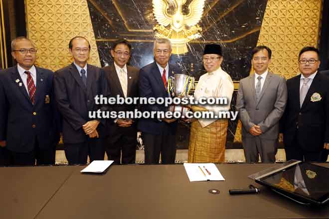  Abang Johari (tiga kanan) menyerahkan trofi cabaran kepada Mohd Anwar sambil disaksikan (dari kiri) Zulkifli, Hoan, Abdul Karim, Hii dan Henry di Kuching semalam. — Gambar Chimon Upon