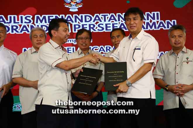  Abang Johari menyaksikan pertukaran dokumen antara Hamden (kiri) dan Ketua Pegawai Eksekutif Sarawak Energy Datu Sharbini Suhaili di Sabal Agroforestry Centre di Jalan Serian-Sri Aman, semalam. — Gambar Muhd Rais Sanusi