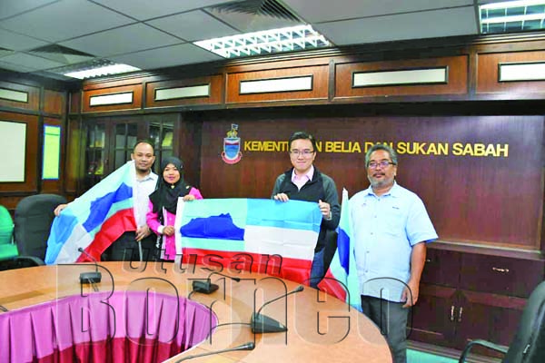 PHOONG menyerahkan bendera Sabah kepada Jumaidah semasa kunjungan hormat.