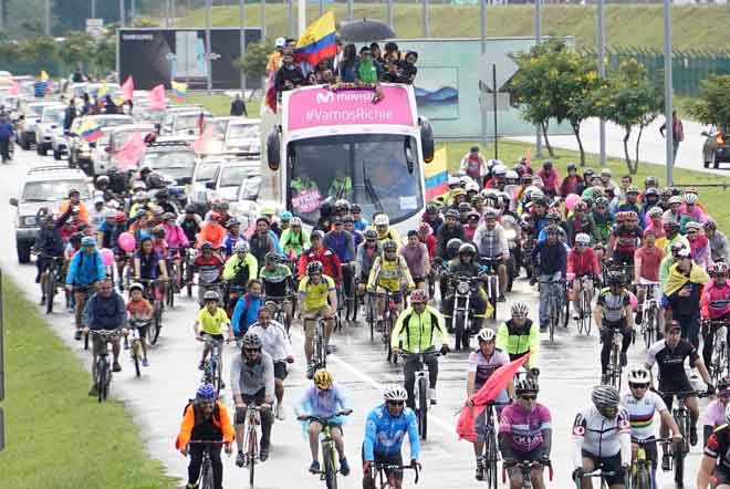  Orang ramai mengiringi bas yang membawa Carapaz dengan menunggang basikal di Ecuador. — Gambar Reuters