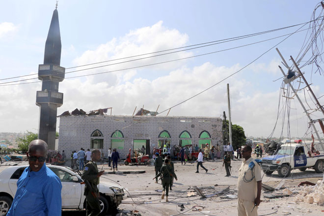  Askar dan orang ramai dilihat di tempat kejadian di Mogadishu, kelmarin. — Gambar AFP