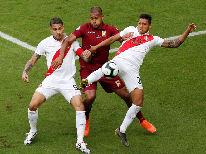   Rondon (tengah) cuba melepasi kawalan dua pemain Peru ketika beraksi pada perlawanan di Arena Do Gremio, Porto Alegre kelmarin. — Gambar AFP 