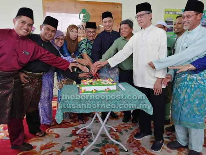  Dr Annuar (lima dari kiri), Yusnar (empat kanan), Wan Hamid (dua kanan), Siaw (tiga kanan) dan yang lain bersama-sama memotong kek sebagai simbolik perasmian Majlis Ramah-Tamah Aidilfitri Kompleks PERYATIM Sibu Jumaat lalu.