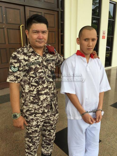  Alister diiringi pegawai penjara di pekarangan Mahkamah Kuching semalam.