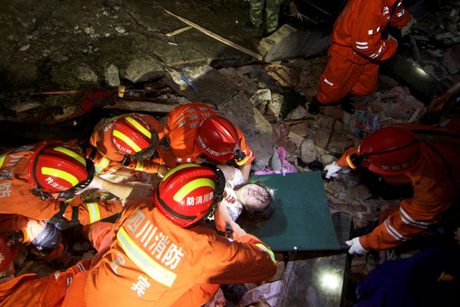  Anggota penyelamat mengangkat seorang wanita yang cedera ketika mereka mencari mangsa terselamat dalam runtuhan bangunan selepas gempa bumi melanda daerah Changning di Yibin, wilayah Sichuan, China semalam. — Gambar China Daily/Reuters
