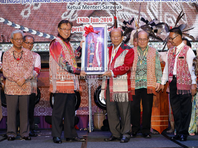  Abang Johari nerima tepa ari Bernard ba pengerami Gawai Ngiling Bidai 2019 di Kuching, malam ensanus. Sama bisi datai Uggah enggau Masing.