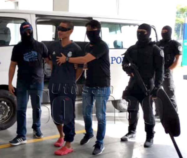 MOHAMMAD Alif diiringi oleh anggota polis dari cawangan Khas Bahagian Anti Pengganas (E8) menuju ke lokap Mahkamah Kota Kinabalu.