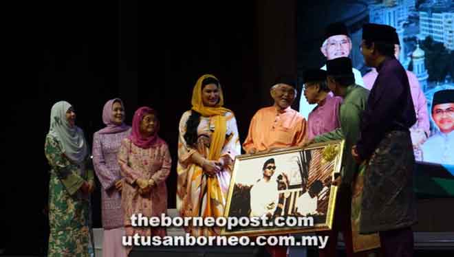  Taib nerima tepa gambar iya ti disuaka Misnu (dua kanan), seraya diperatika Abang Johari (tiga kanan) enggau kebukai nyerumba penerami Majlis Kesyukuran Aidilfitri Agensi-Agensi Islam, malam ensanus.