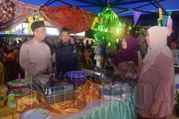 ARIFF (kiri) dan Alhazmi bertanya khabar kepada penyedia gerai makanan.