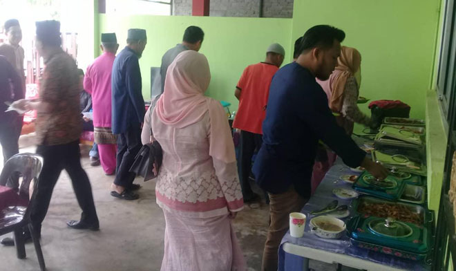  Tetamu majlis rumah terbuka Hari Raya Aidilfitri anjuran Muhamad mengambil juadah masing-masing.