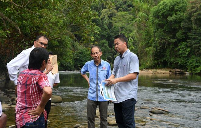  Peter (kanan) berbincang bersama penduduk sambil melihat peta lokasi Sungai Papar ketika melawat lokasi pembinaan empangan Papar semalam. — Gambar Bernama 