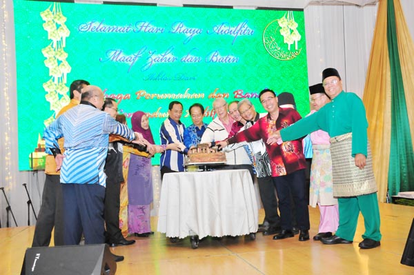 JAUJAN (tengah) bersama tetamu kehormat lain menyempurnakan acara memotong kek.