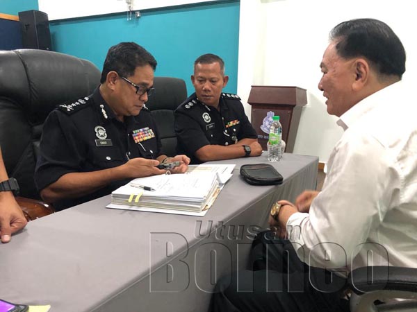 Omar Mammah memeriksa dokumen pistol milik Tan Sri Anddre Liew yang merupakan pengerusi Jawatankuasa Perhubungan Yayasan Pencegahan Jenayah Malaysia (MCPF) Sabah sambil diperhatikan oleh Ketua Polis Daerah Sandakan ACP Mohd Azhar Hamin.