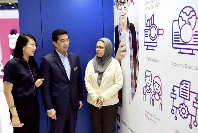  Azmin (tengah) mendengar penerangan daripada Pengarah Sumber Manusia Experian Chua Chai Ping (kiri) ketika melawat ruang Pameran ‘Graduan Aspire Career’ di Pusat Konvensyen Kuala Lumpur (KLCC), semalam. — Gambar Bernama