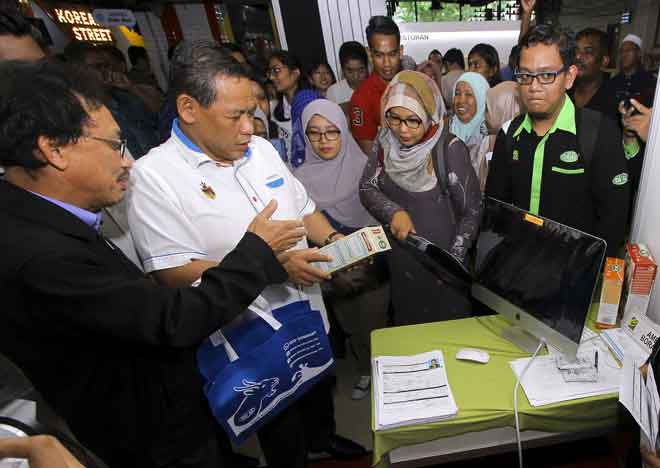  Aminuddin (dua kiri) mendengar penerangan daripada Ketua Pegawai Eksekutif Cipta Success Marketing Yaakop Mohd Isa (kiri) mengenai hasil produk syarikatnya pada Majlis Perasmian Karnival Pekerjaan dan TVET Negeri Sembilan di Palm Mall, semalam. — Gambar Bernama