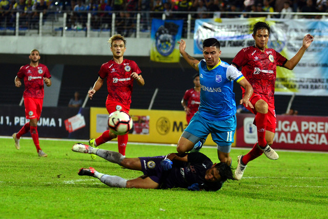 Penyerang Pulau Pinang, Sergio Fabian Ezequiel Aguero diasak pemain Sarawak pada aksi Liga Premier di Stadium Bandaraya malam tadi. - Gambar Bernama