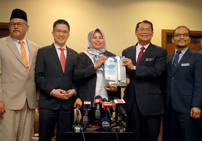  Ketua Audit Negara Nik Azman Nik Abdul Majid (dua kanan) menyerahkan buku laporan kepada Dr Noraini Ahmad (tiga kiri) ketika sidang media, semalam. — Gambar Bernama