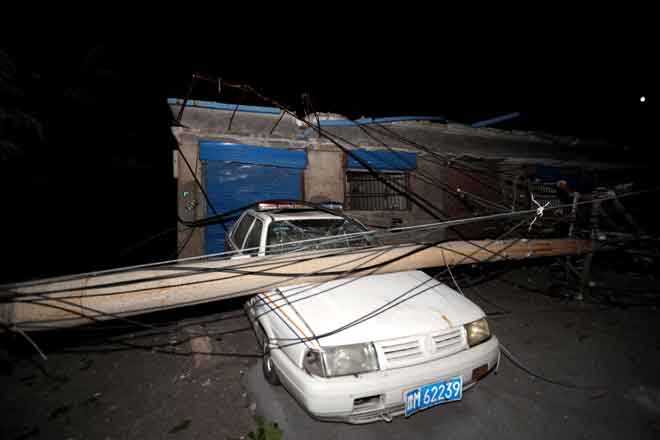  Sebuah kereta dihempap tiang dekat lokasi letupan di kilang Henan Coal Gas Group di bandar Yima, wilayah Henan di tengah China semalam. — Gambar AFP