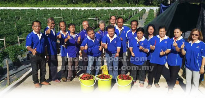  Hu (tujuh kiri), Tuai Rumah Selia (enam kiri) merakam kenangan bersama rombongan KRT Sungai Durin selepas melawat tapak projek tanaman cili secara fertigasi di Jalan Durin.