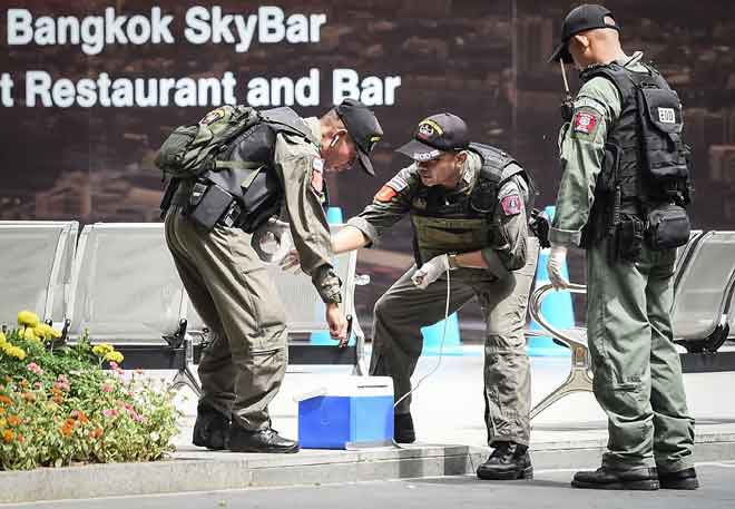  Anggota unit pemusnah bom dilihat di tapak letupan bom di Bangkok, Thailand semalam. — Gambar AFP