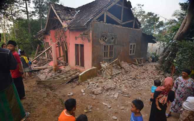  Penduduk kampung melihat kerosakan sebuah rumah di Pandeglang, wilayah Banten semalam selepas gempa bumi kuat melanda kawasan itu. — Gambar AFP