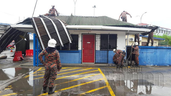  Anggota bomba semasa melakukan operasi menurunkan atap pejabat yang diterbangkan angin.