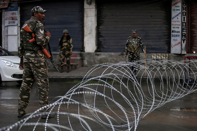  Anggota pasukan keselamatan India dilihat berkawal dekat gulungan wayar berduri ketika perintah berkurung dikuatkuasakan selepas kerajaan haluan kanan menarik balik status khas untuk Kashmir, di Srinagar kelmarin. — Gambar Reuters