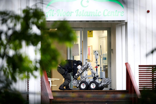  Seorang lelaki mengendalikan robot polis di pintu masuk ke Pusat Islam Al-Noor di Oslo, Norway kelmarin selepas seorang lelaki melepaskan tembakan dalam masjid tersebut dan mencederakan seorang individu. — Gambar NTB Scanpix/Terje Pedersen via Reuters