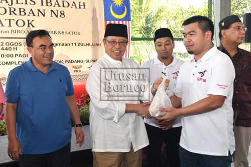 Abang Johari mengagihkan daging korban kepada penerima pada majlis Ibadah Korban N8 Satok anjuran Biro Agama Parti Pesaka Bumiputera Bersatu (PBB) di Kompleks Sukan Satok, Padang Slps hari ini. Gambar oleh Muhammad Rais Sanusi