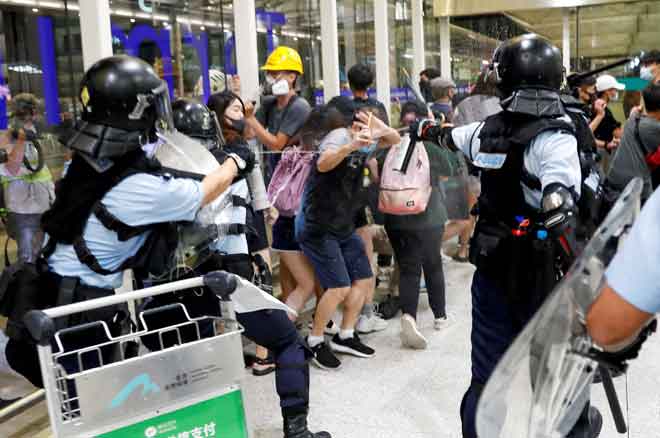  Polis menggunakan penyembur lada untuk menyuraikan penunjuk perasaan selepas rapat umum bertukar ganas di lapangan terbang Hong Kong, China kelmarin. — Gambar Reuters