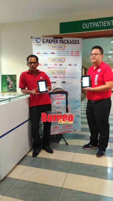  Justyn (kanan) dan Francis menunjukkan e-paper See Hua Marketing yang sedang dalam rangka promosi di Normah semalam.