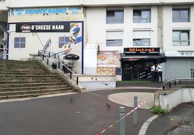  Anggota polis melakukan siasatan berkenaan kes tembakan maut terhadap seorang pelayan di luar bangunan restoran tersebut di Paris. — Gambar AFP