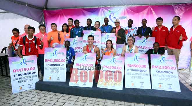  Pemenang-pemenang bersama Abang Wahap (lima kanan) dan tetamu lain pada majlis penyampaian hadiah Kuching Marathon 2019 semalam. — Gambar Muhammad Rais Sanusi