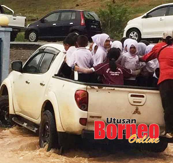  Murid-murid ini terpaksa menaiki kenderaan pacuan empat roda beramai-ramai akibat banjir kilat yang menimpa sekolah mereka.