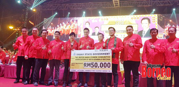  Junz (empat kanan) mewakili kerajaan negeri menyerahkan cek replika bernilai RM50,000 kepada Susan (lima kiri).