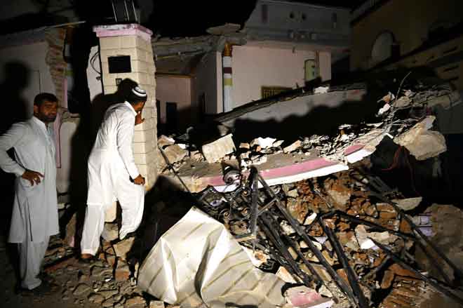  Penduduk meninjau bangunan yang runtuh selepas gempa bumi cetek melanda           berhampiran kota Mirpur di timur laut Pakistan kelmarin. — Gambar AFP     Pakistani men stand beside a collapsed building following an earthquake on the outskirts of Mirpur on September 24, 2019. - At least 19 people have been killed and 300 wounded after a shallow earthquake rattled north-eastern Pakistan, a senior police officer said, with the tremor tearing car-sized cracks into roads and heavily damaging infrastruc