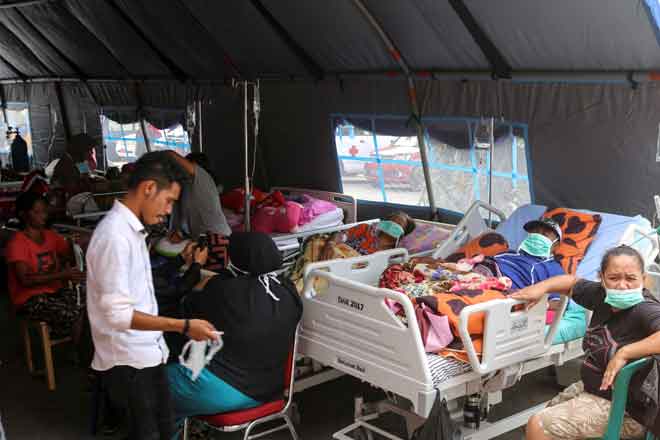  Penduduk yang cedera menerima rawatan di pusat penempatan sementara di luar hospital Dr. M. Haulussy selepas gempa bumi melanda Ambon di Kepulauan Maluku, Indonesia kelmarin. — Gambar Antara Foto/Izaac Mulyawan/Reuters