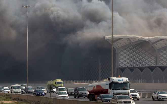  Kenderaan bergerak melalui kepulan asap tebal dari stesen kereta api berkelajuan tinggi Haramain di bandar Jeddah barat Arab Saudi kelmarin, selepas api mula merebak di stesen tersebut. — Gambar AFP