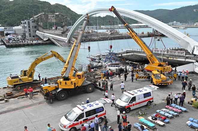  Anggota penyelamat dilihat bersedia untuk membantu mangsa selepas sebuah jambatan runtuh dan menyebabkan sekurang-kurangnya 14 orang cedera di pelabuhan Nanfangao di pantai timur Taiwan semalam. — Gambar Sam Yeh/AFP
