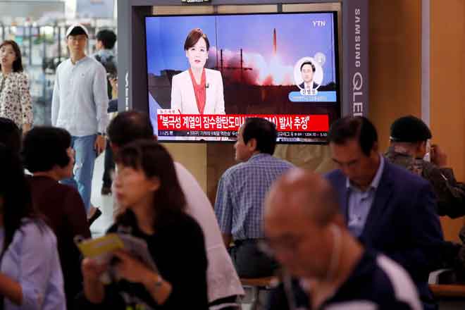  Orang ramai menonton berita mengenai misil balistik Korea Utara yang dipercayai              dilancarkan oleh kapal selam, di stesen kereta api di Seoul, Korea Selatan semalam. — Gambar Reuters 