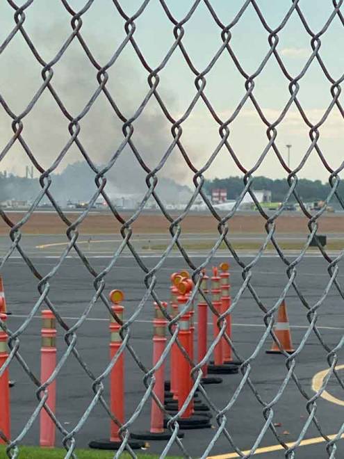  Asap dilihat dari tapak sebuah pesawat vintaj terhempas di Lapangan Terbang Antarabangsa Bradley, Connecticut, Amerika Syarikat kelmarin. — Gambar Bryan St. Amand/Reuters