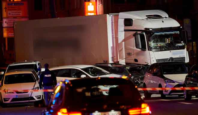  Seorang pegawai polis dilihat mengambil gambar sebuah trak curi yang merempuh beberapa kereta di lampu isyarat                  di bandar Limburg, tengah Jerman kelmarin. — Gambar Sascha Ditscher/dpa/AFP