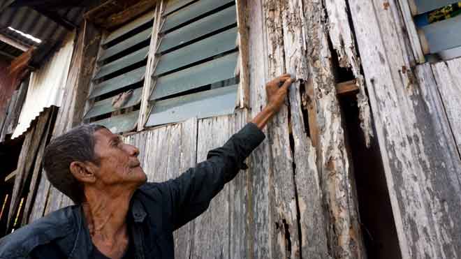  Nelayan,  Yaacob Ibrahim, 66 menunjukkan dinding yang reput dan berlubang akibat dimakan anai-anai di rumahnya di Lorong Kompleks, Kampung Tengah, Kuala Kedah di Alor Setar, semalam. — Gambar Bernama