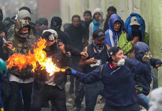  Penunjuk perasaan melontar bom minyak ke arah polis rusuhan ketika membantah pemansuhan subsidi bahan bakar di Quito, Ecuador kelmarin. — Gambar Ivan Alvarado/Reuters