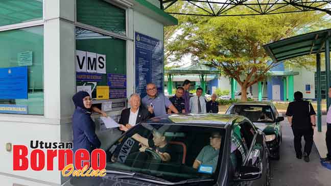  Ting dan Sharifah Halimah membantu pemandu dari Brunei semasa pelancaran VMS Jabatan Kastam Diraja Malaysia (JKDRM) Miri di CIQ Sungai Tujoh disaksikan Datuk Bandar Majlis Bandaraya Miri (MBM) Adam Yii.