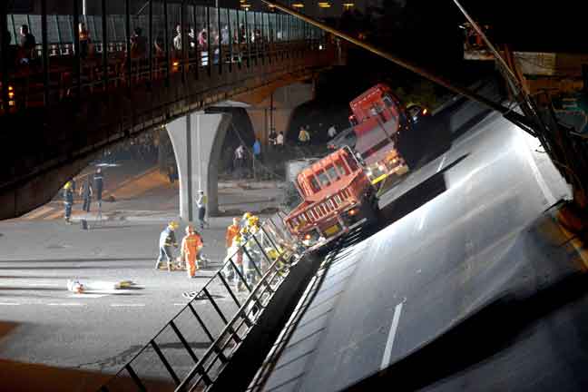  Kenderaan dan anggota penyelamat dilihat bekerja di tapak di mana sebuah jejambat lebuh raya runtuh                          di Wuxi, wilayah Jiangsu, China kelmarin. — Gambar China Daily/Reuters