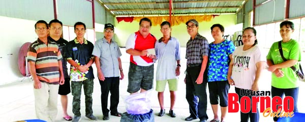  Wong (lima kiri) menyerahkan bantuan kepada mangsa.