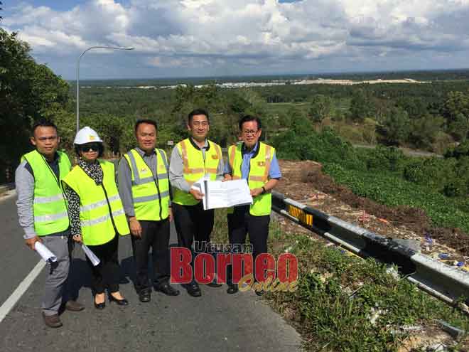  (Dari kanan) Lee dan Chong menunjukkan spesifikasi kerja membaik pulih cerun di Bukit Kanada, Miri semalam.