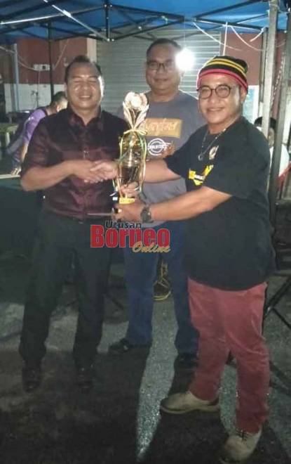  Lugat (kanan) menyampaikan hadiah kepada Taha Ariffin yang telah muncul juara pada Pertandingan Karaoke anjuran PEDAS Sarikei, malam kelmarin.